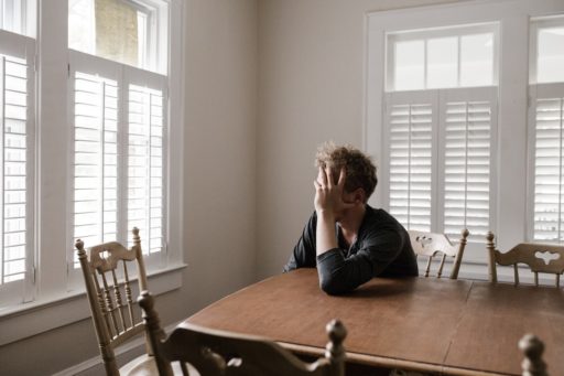 photo-of-man-leaning-on-wooden-table-3132388